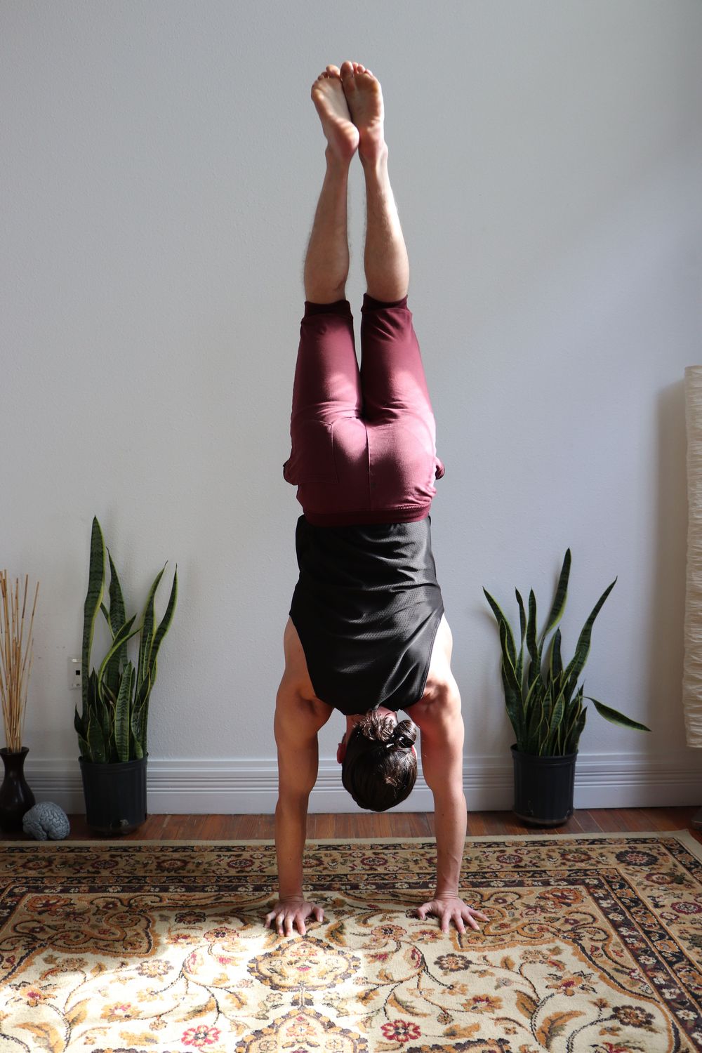Anthony in a handstand on a patterned rug
